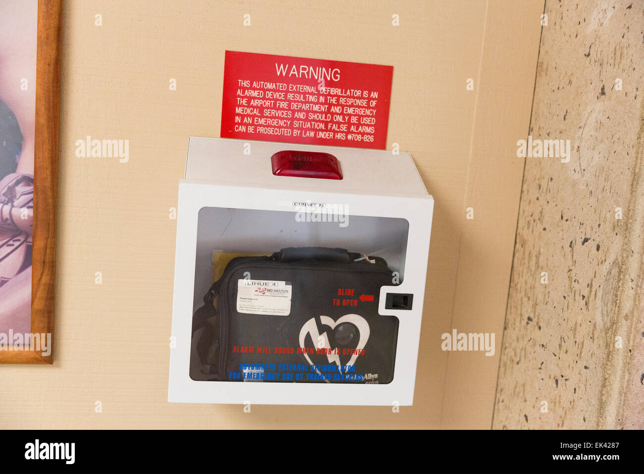 Portable automated external defibrillator (AED) mlunted on the wall in the public restroom at the airport Stock Photo