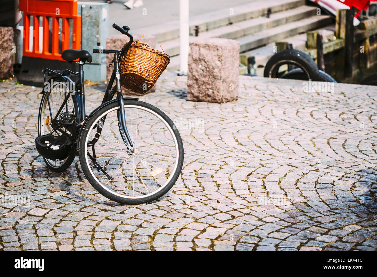 Parked Black Bicycle With Basket On Sidewalk. Bike Parking In European City. Toned Instant Filtered Photo Stock Photo