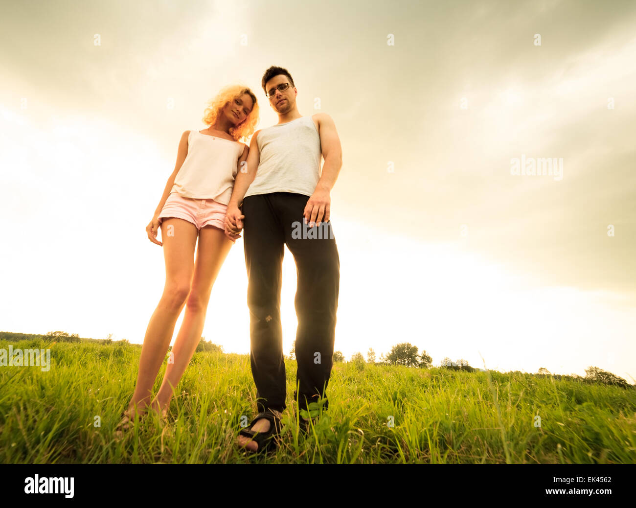 couple walking through the field and holding hands Stock Photo - Alamy