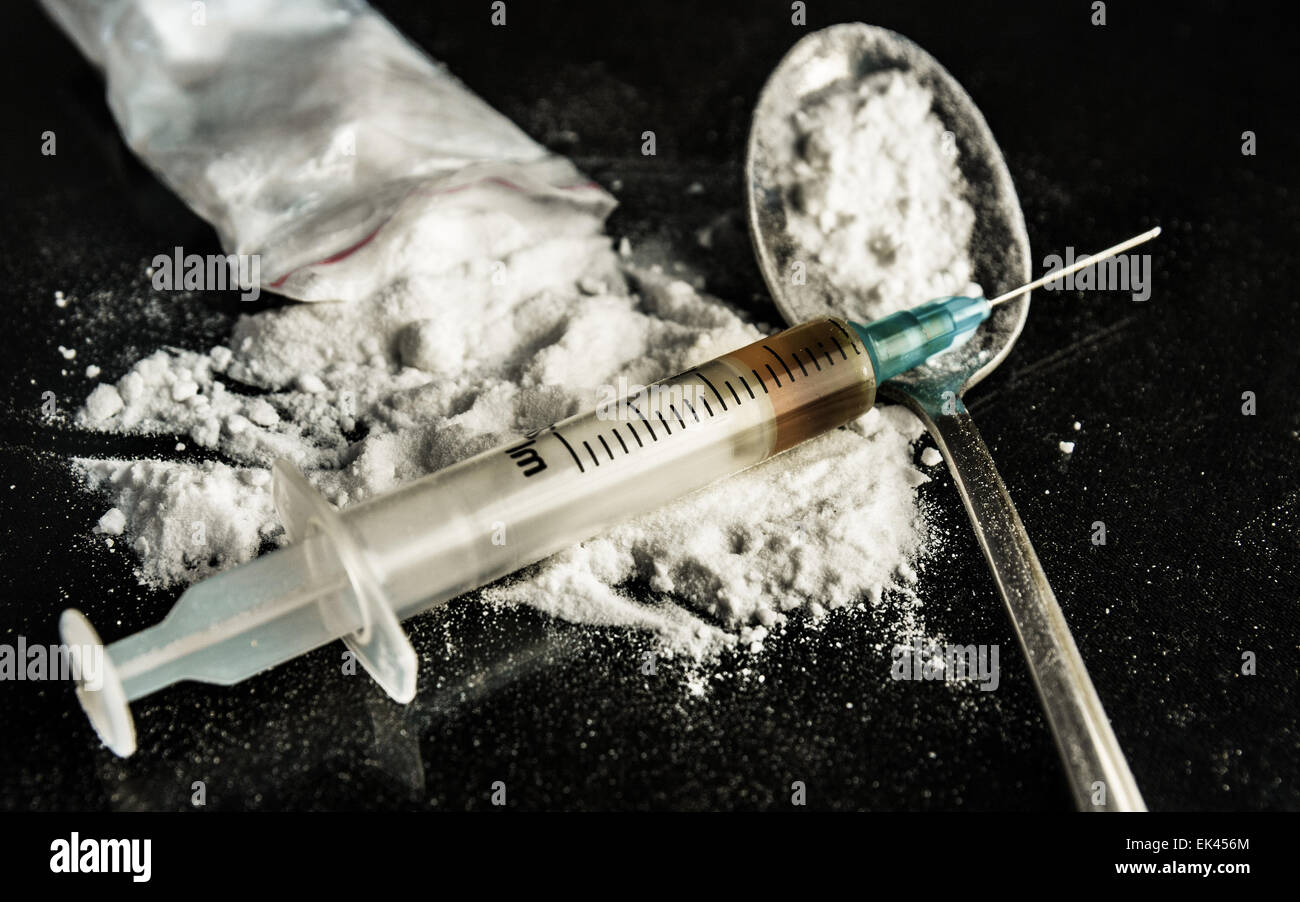 Drug syringe and cooked heroin Stock Photo