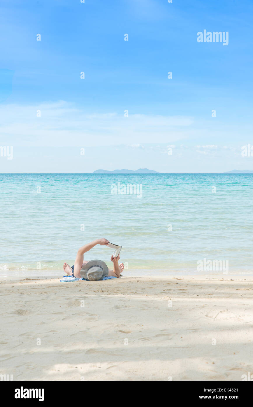Summer, Travel, Vacation and Holiday concept - Man resting on beach and reading book in Phuket,Thailand Stock Photo