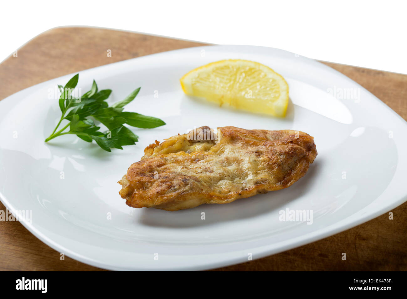 Fried pork brains with lemon and parsley on the plate Stock Photo