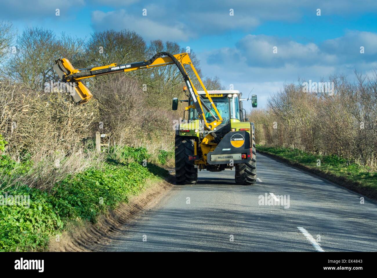 Mechanized hedge cutting on a country road Stock Photo