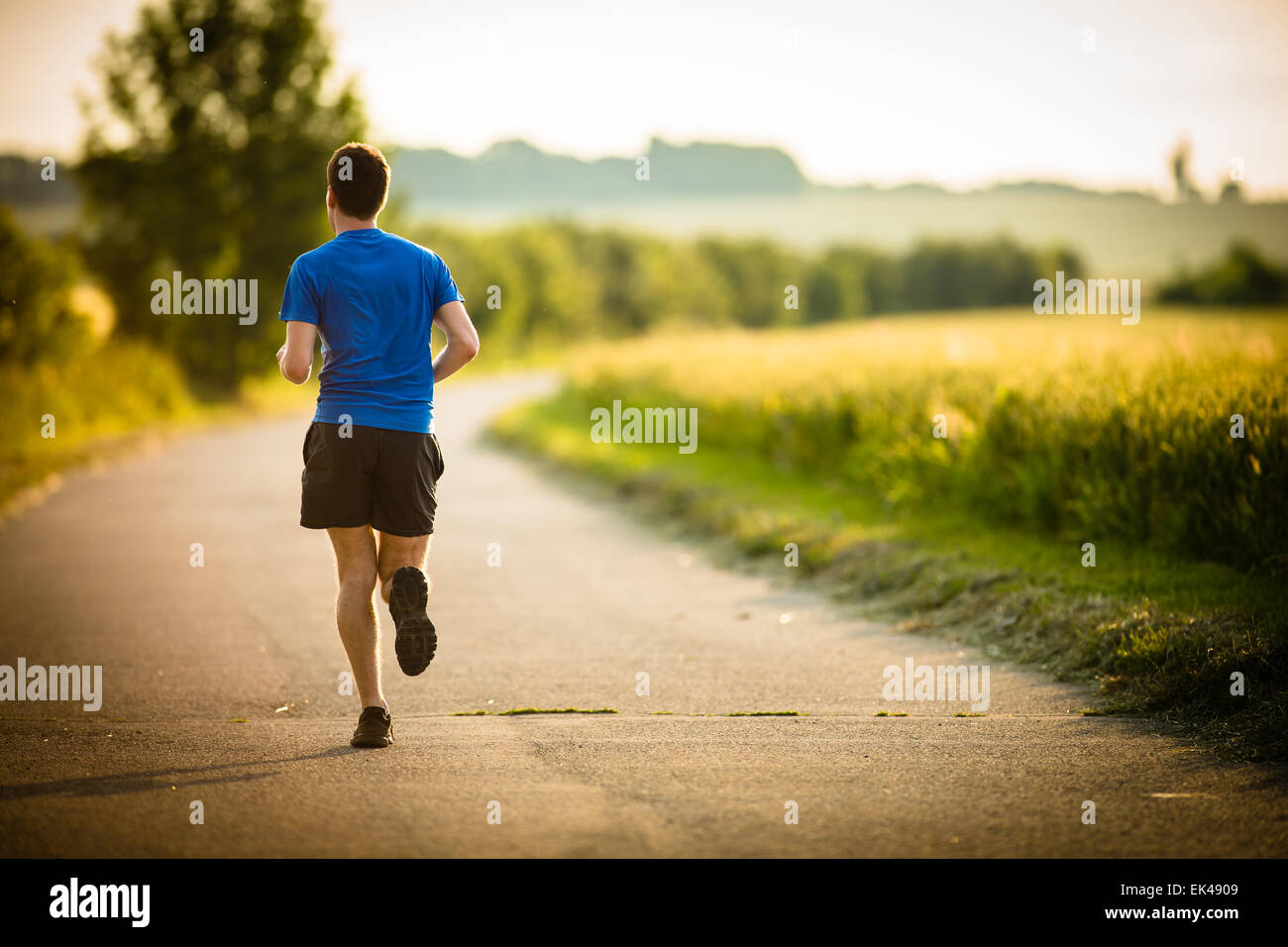 Male athlete/runner running on road jog workout wellbeing concept