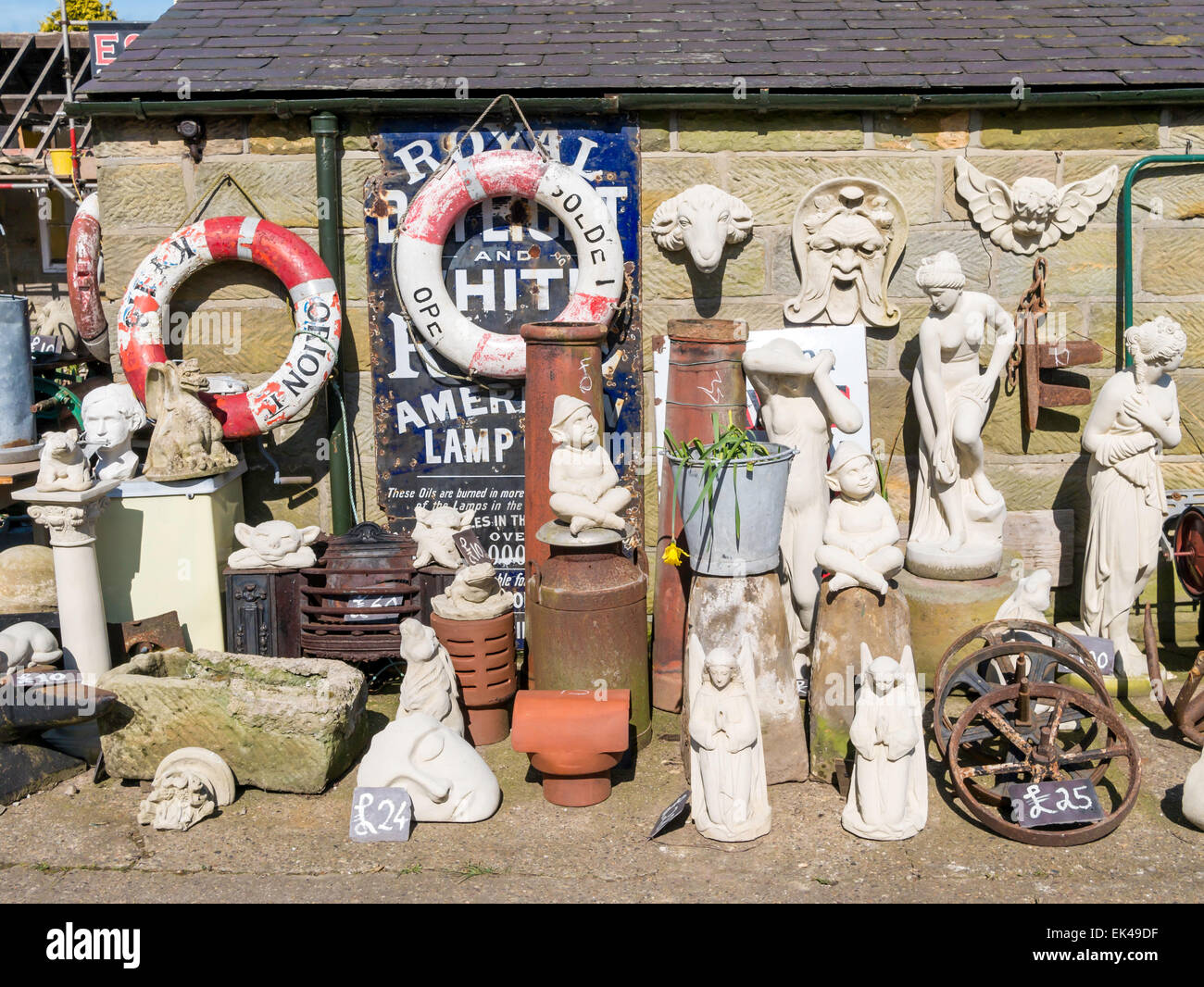 A collection of garden ornament statues outside a rural antique shop