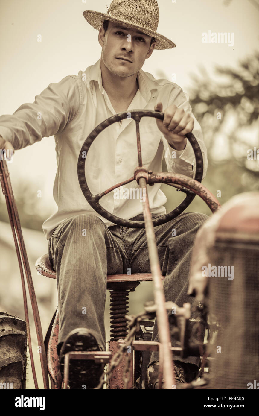 Young Farmer Driving a Red Old Vintage Tractor Stock Photo - Alamy