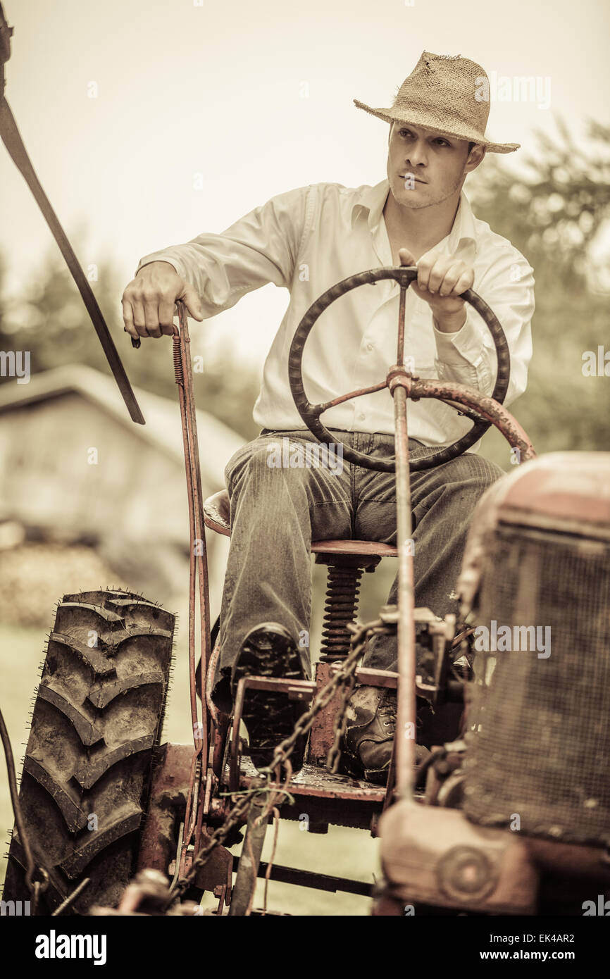 Young Farmer Driving a Red Old Vintage Tractor Stock Photo - Alamy