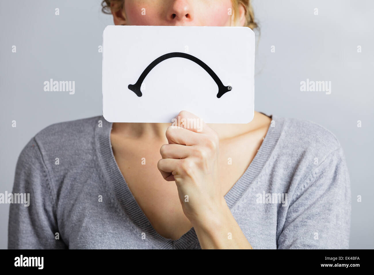 Unhappy Portrait of a Woman Holding a Sad Mood Board Stock Photo