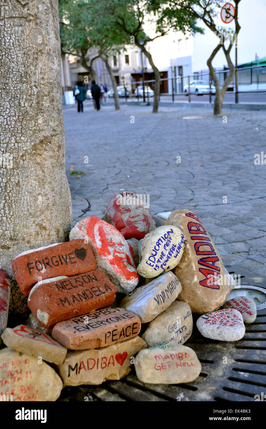 The people of South Africa honour Mandela in many different ways. Painted rocks with Mandela's image and some of his quotes  andvalues outside parliament, Cape Town. Stock Photo