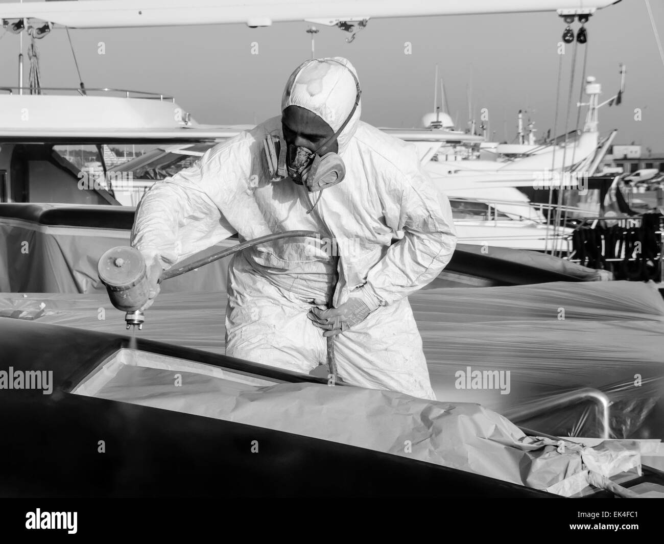 Italy, Tuscany, Viareggio, worker spray painting the backside of a