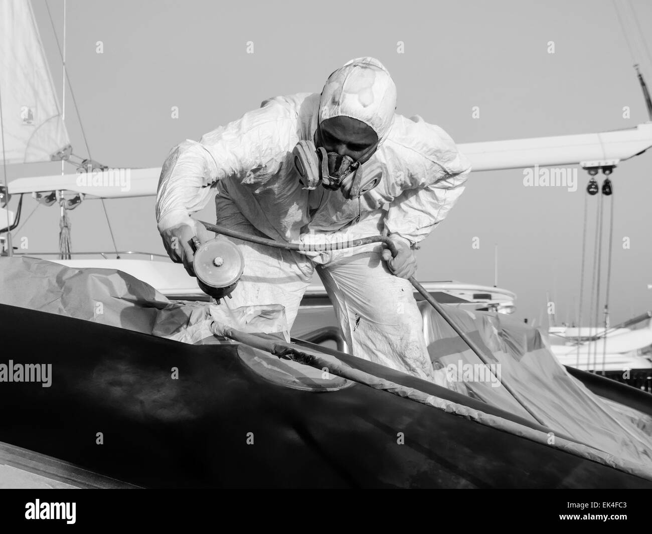 Italy, Tuscany, Viareggio, worker spray painting the backside of a