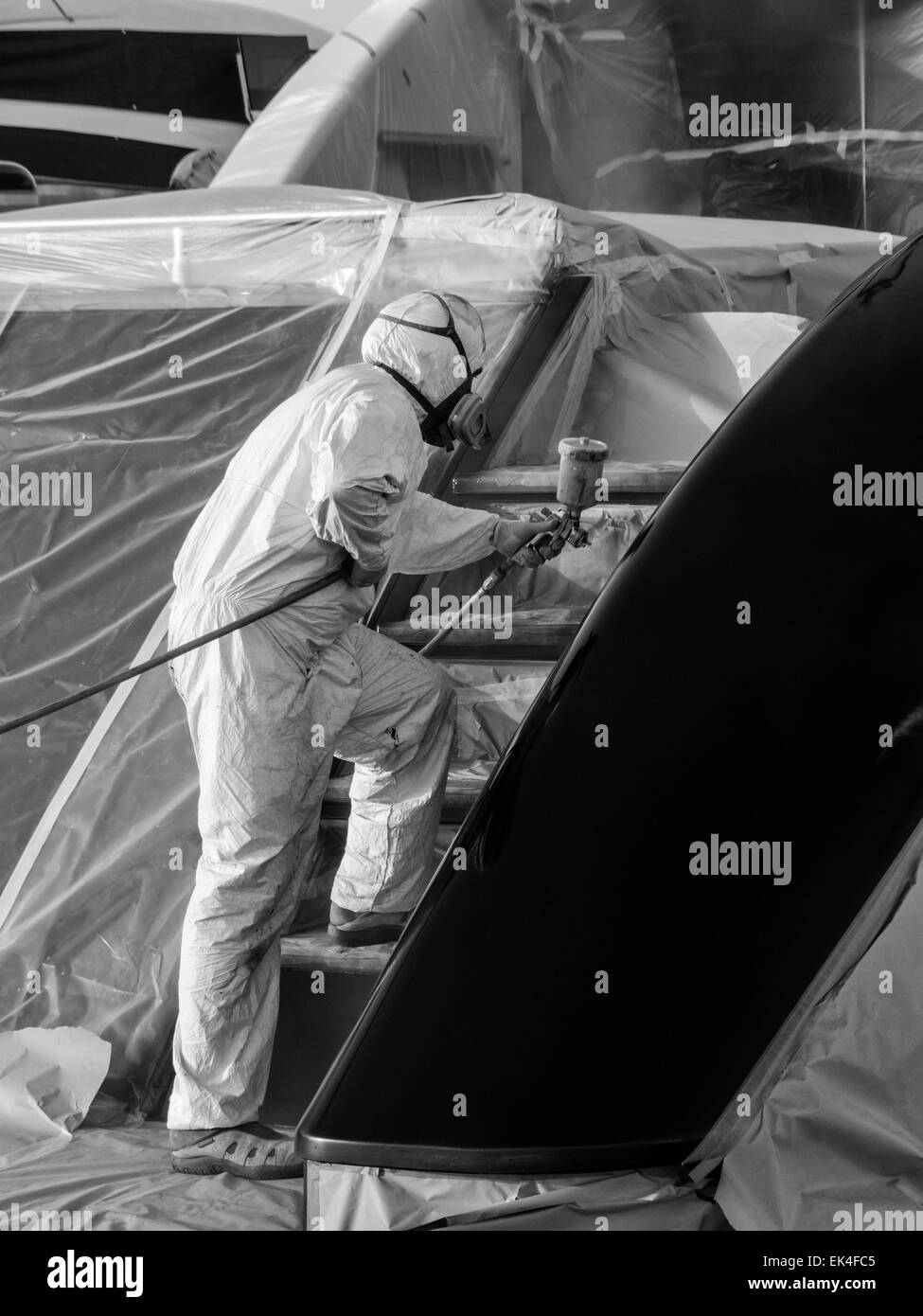Italy, Tuscany, Viareggio, worker spray painting the backside of a