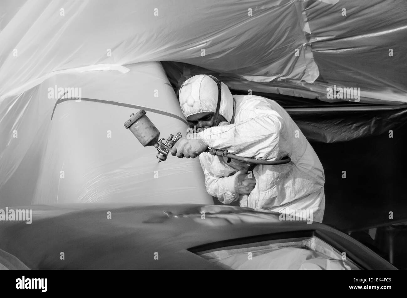 Italy, Tuscany, Viareggio, worker spray painting the backside of a