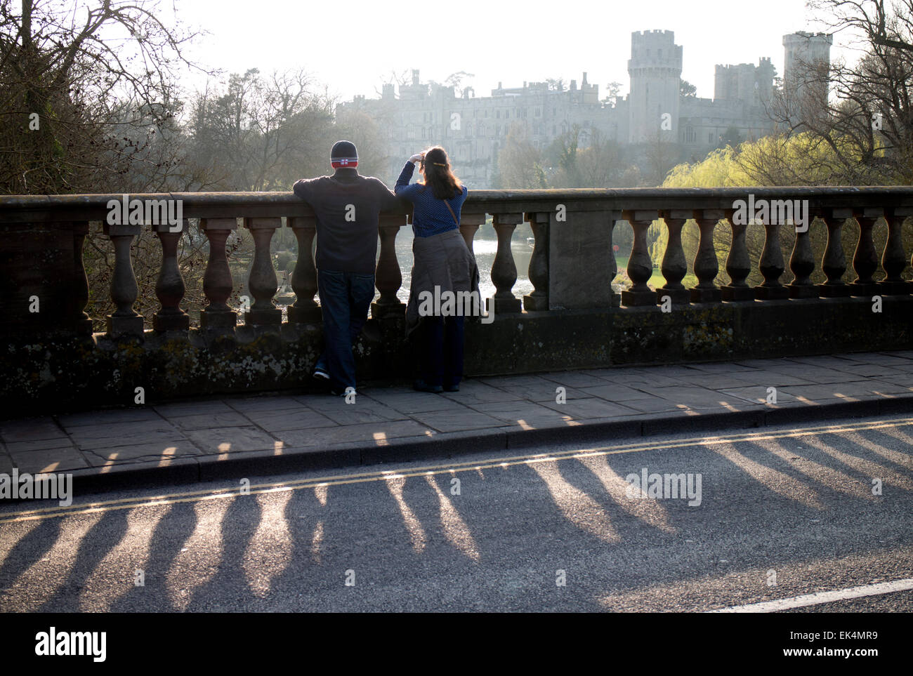 Couple looking at Warwick Castle from the Banbury Road bridge, Warwickshire, UK Stock Photo