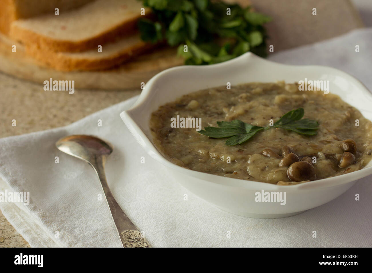 Shot of mushroom and potatoes cream soup in white bowl Stock Photo