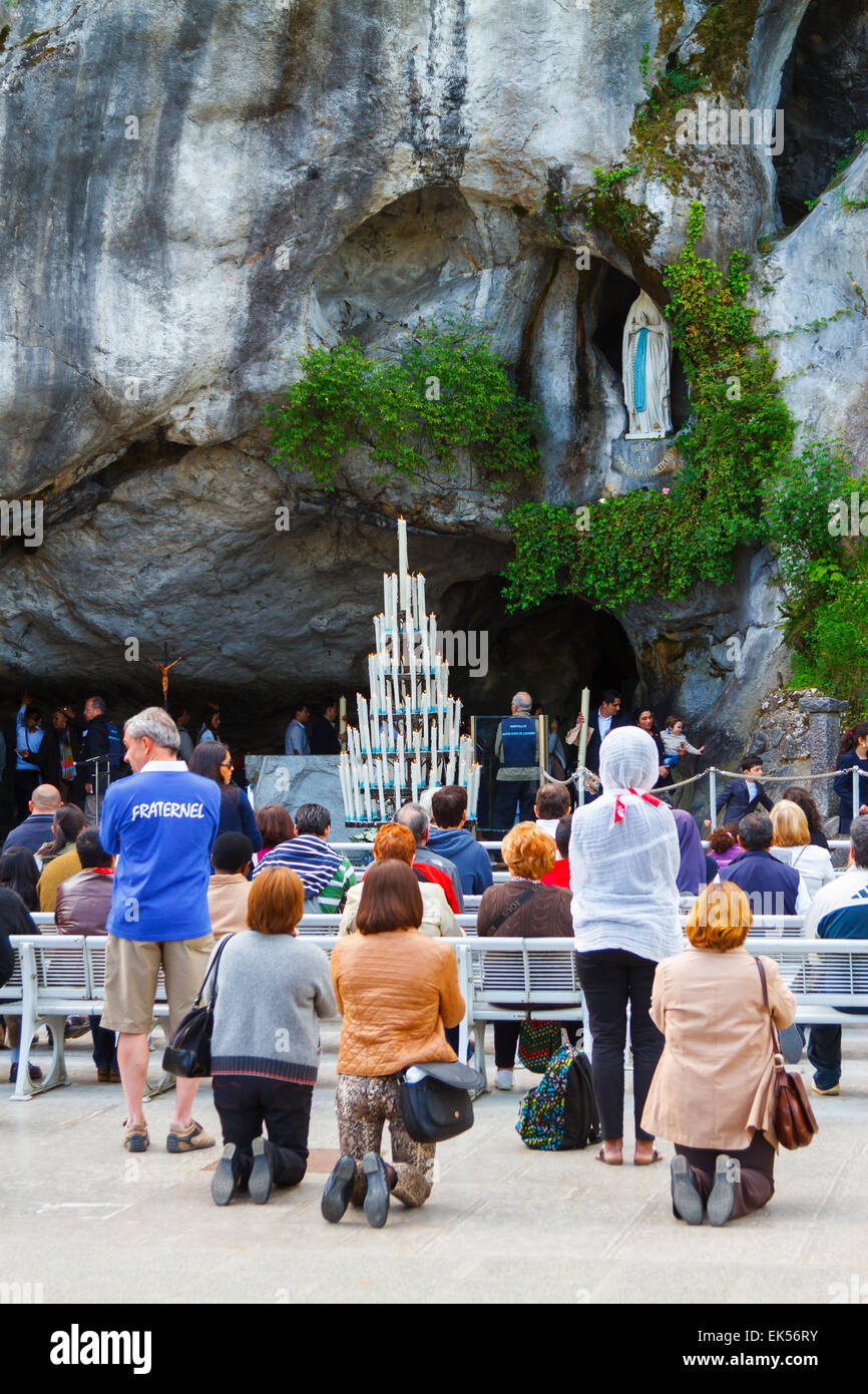 Massabielle grotto, statue of Our Lady of Lourdes and pilgrims. Lourdes city.  Midi-Pyrenees region, France, Europe. Stock Photo