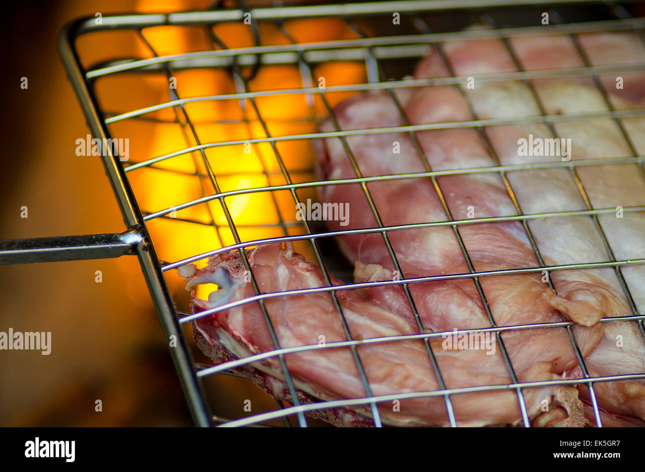 Grill with meat for barbecue and fire in background for dinner Stock ...
