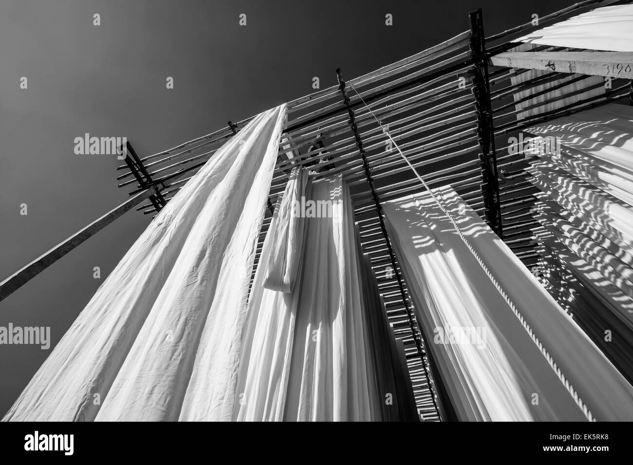 India, Rajasthan, Jaipur, indian man hanging cotton clothes to dry