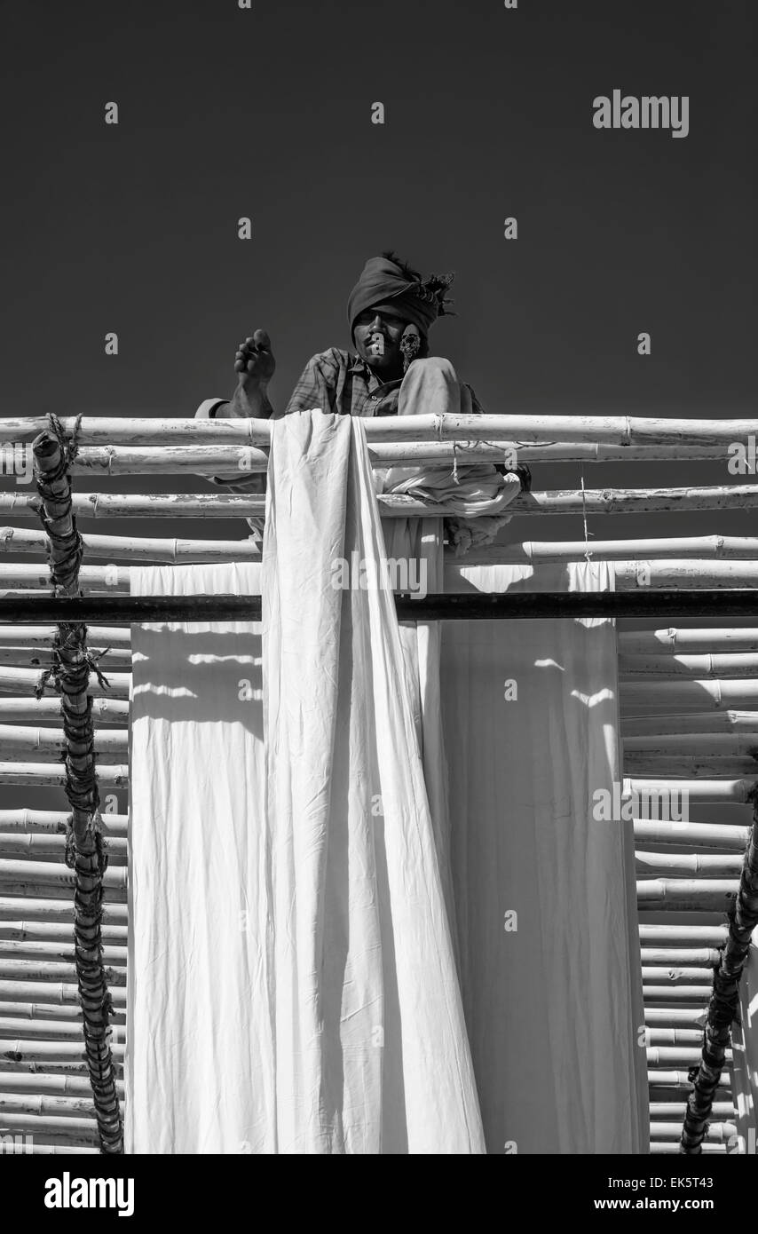 India, Rajasthan, Jaipur, indian man hanging cotton clothes to dry under the sun Stock Photo