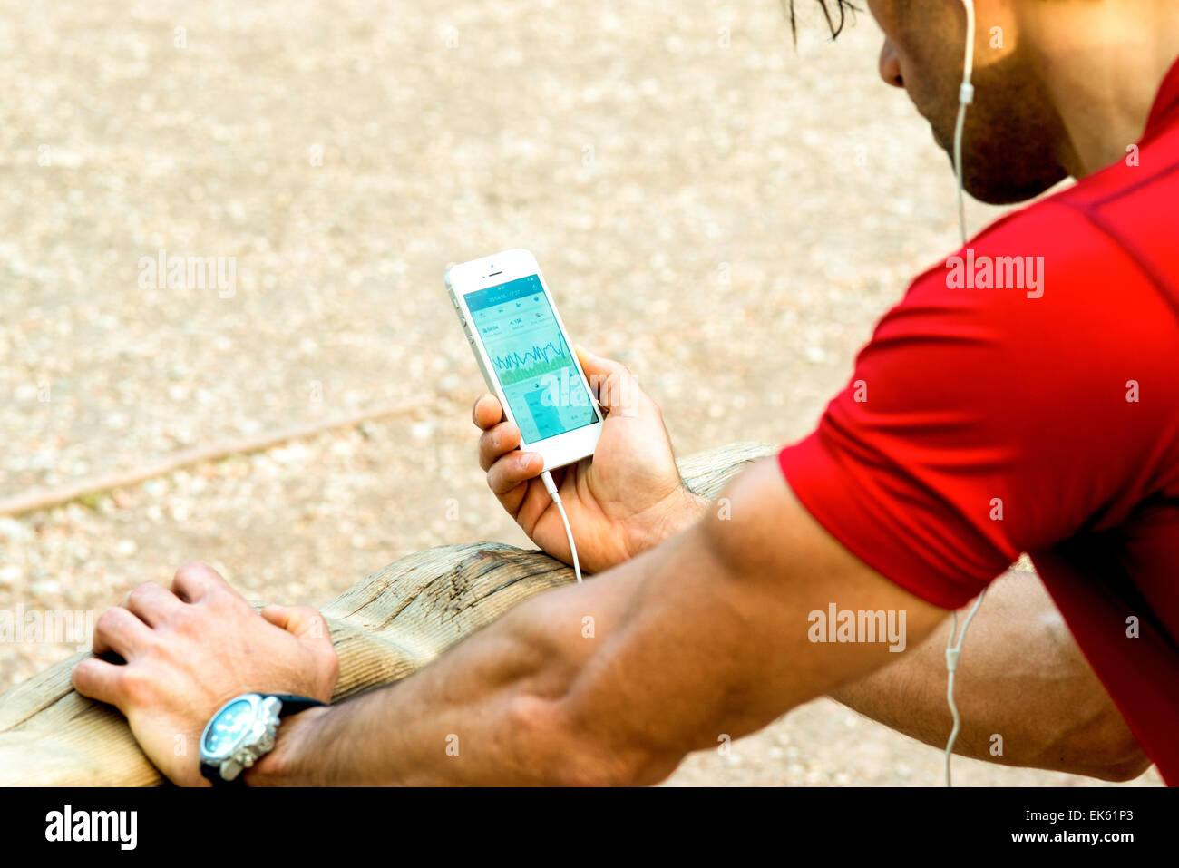 A guy that is reviewing his sport performance on his mobile phone after running Stock Photo