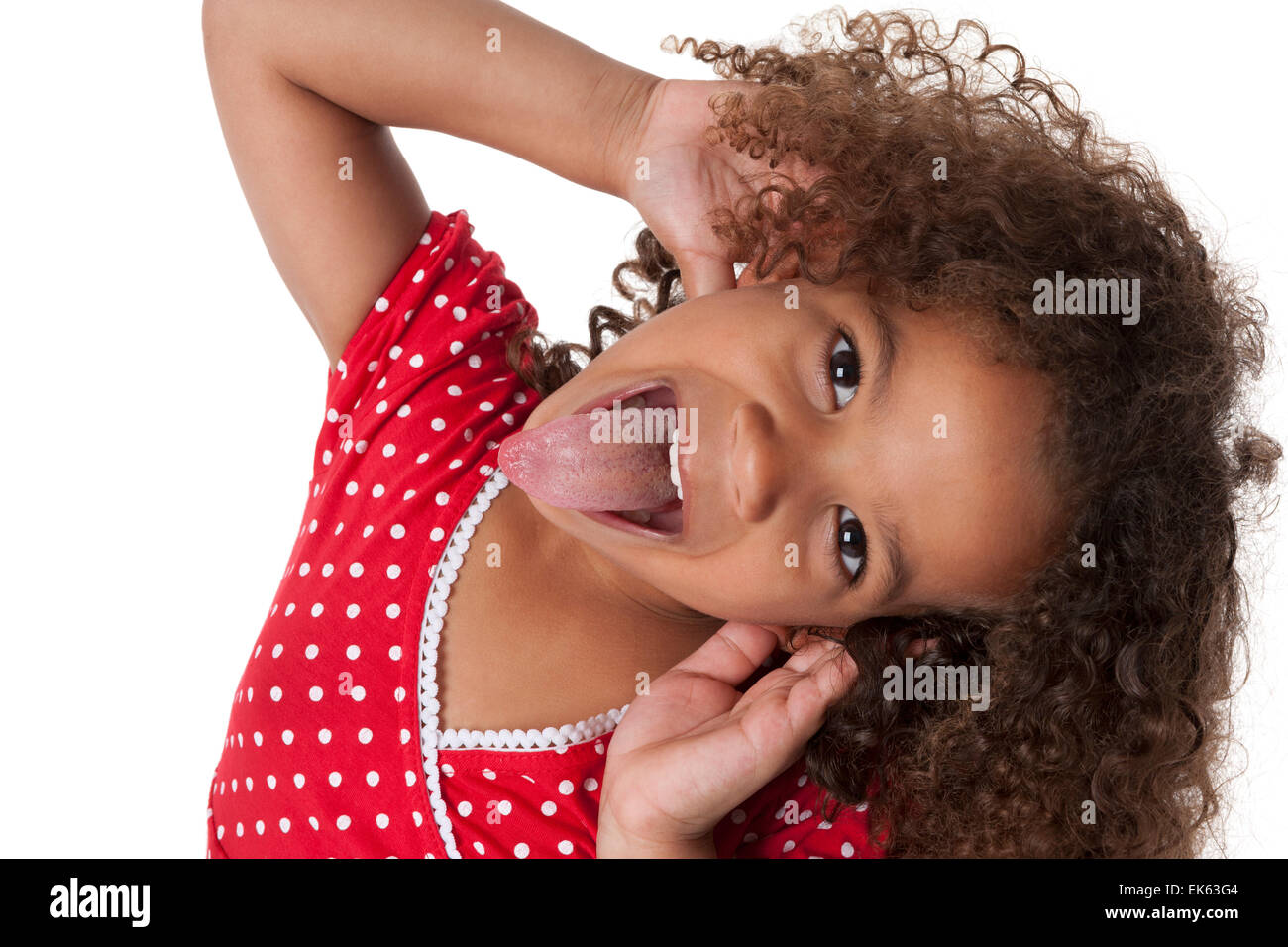 Portrait of a five year old girl making faces and sticking out her tongue on white background Stock Photo