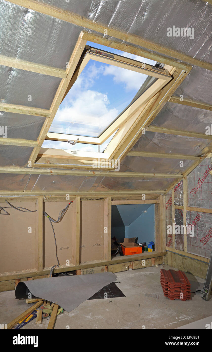 a newly installed roof window within a partially complete loft conversion project in South London Stock Photo