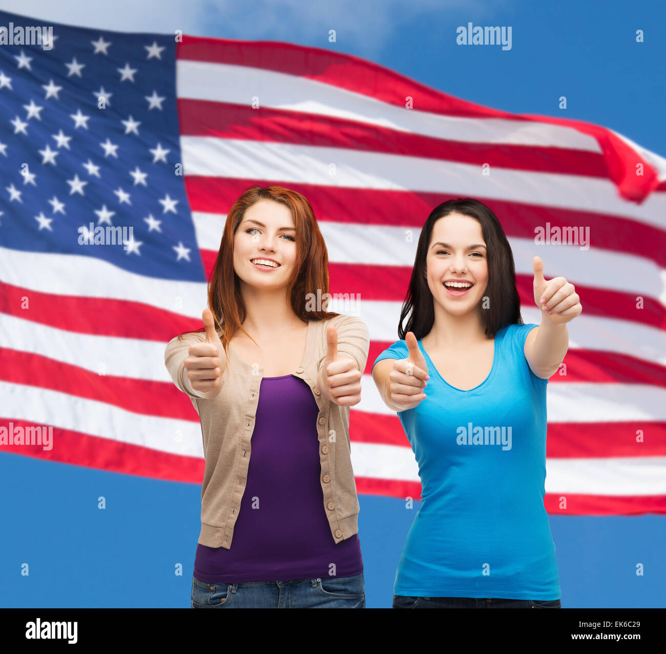 two smiling girls showing thumbs up Stock Photo - Alamy