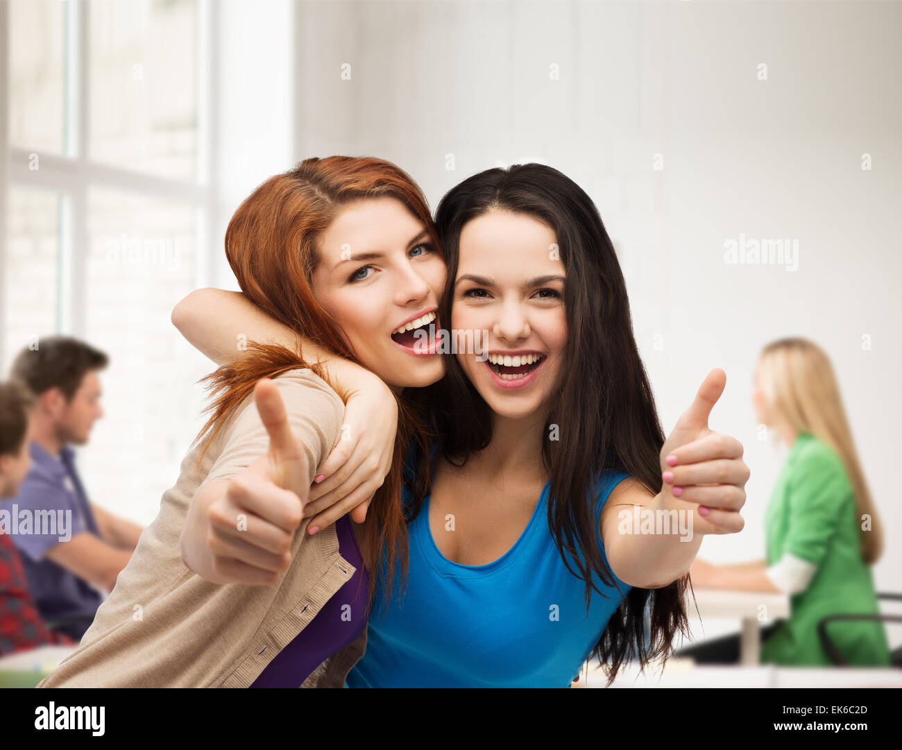 two smiling girls showing thumbs up Stock Photo - Alamy