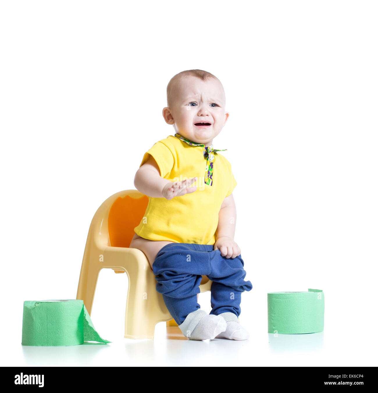 crying child sitting on chamber pot with toilet paper Stock Photo