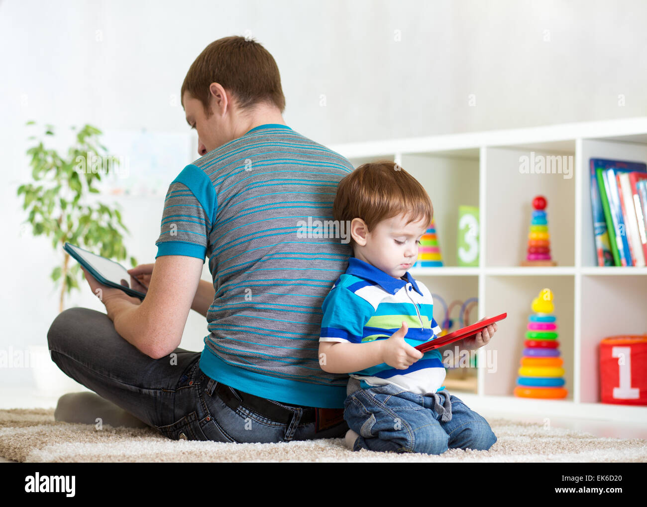 Loneliness of child and father playing with tablet at home Stock Photo