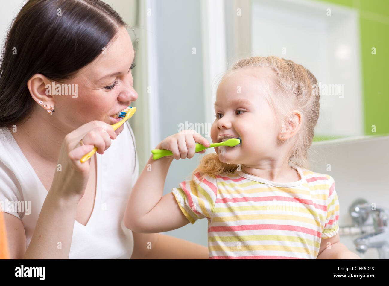 cute mom teaching kid teeth brushing Stock Photo