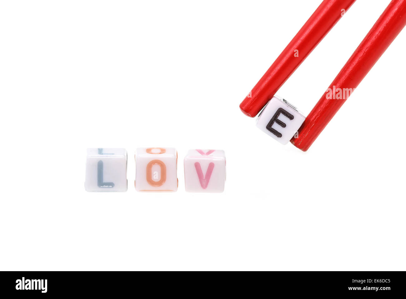 Love written in letter beads with chopsticks holding E isolated on white background Stock Photo