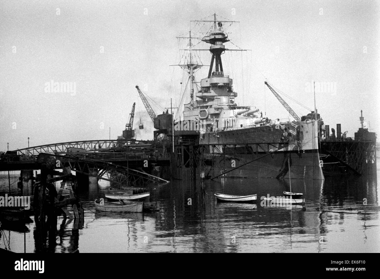 AJAXNETPHOTO. 1920-1930S. PORTSMOUTH, ENGLAND. - BATTLESHIP REFIT - A ROYAL SOVEREIGN CLASS BATTLESHIP, POSSIBLY HMS ROYAL OAK (SUNK 10/1939) OR HMS REVENGE, IN THE HUGE FLOATING DOCK LOCATED NR FLATHOUSE QUAY. NOTE THE LINKSPAN CONNECTING THE DOCK TO FOUNTAIN LAKE JETTY. SISTER SHIP ROYAL SOVEREIGN WAS BUILT IN PORTSMOUTH.  PHOTO:AJAX VINTAGE PICTURE LIBRARY REF:()AVL Stock Photo