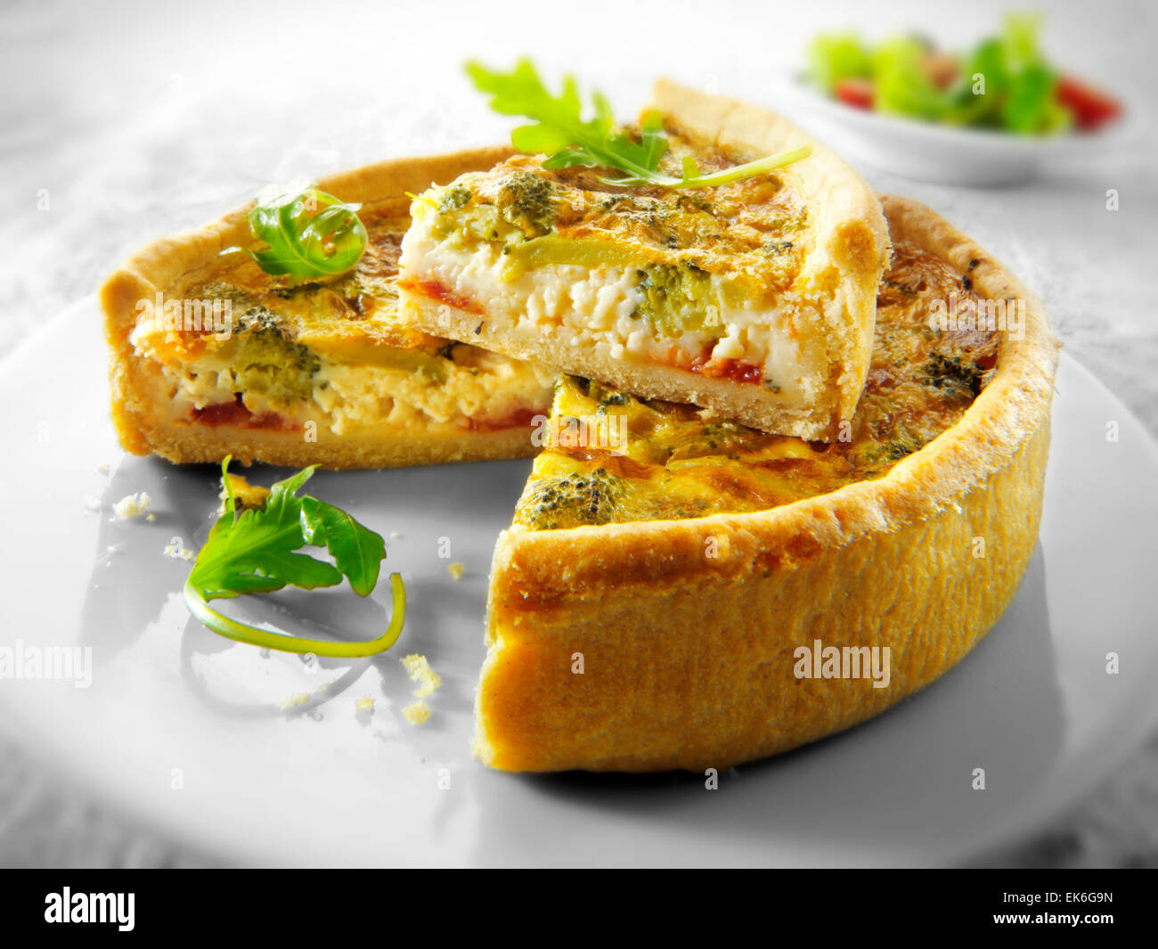 Whole cooked brocoli quiche with a slice out Stock Photo