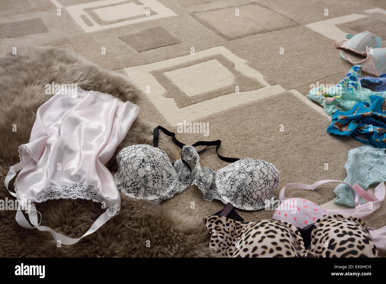 Female undergarment lingerie bras panties slip strewn on a brown carpeted  floor Stock Photo - Alamy