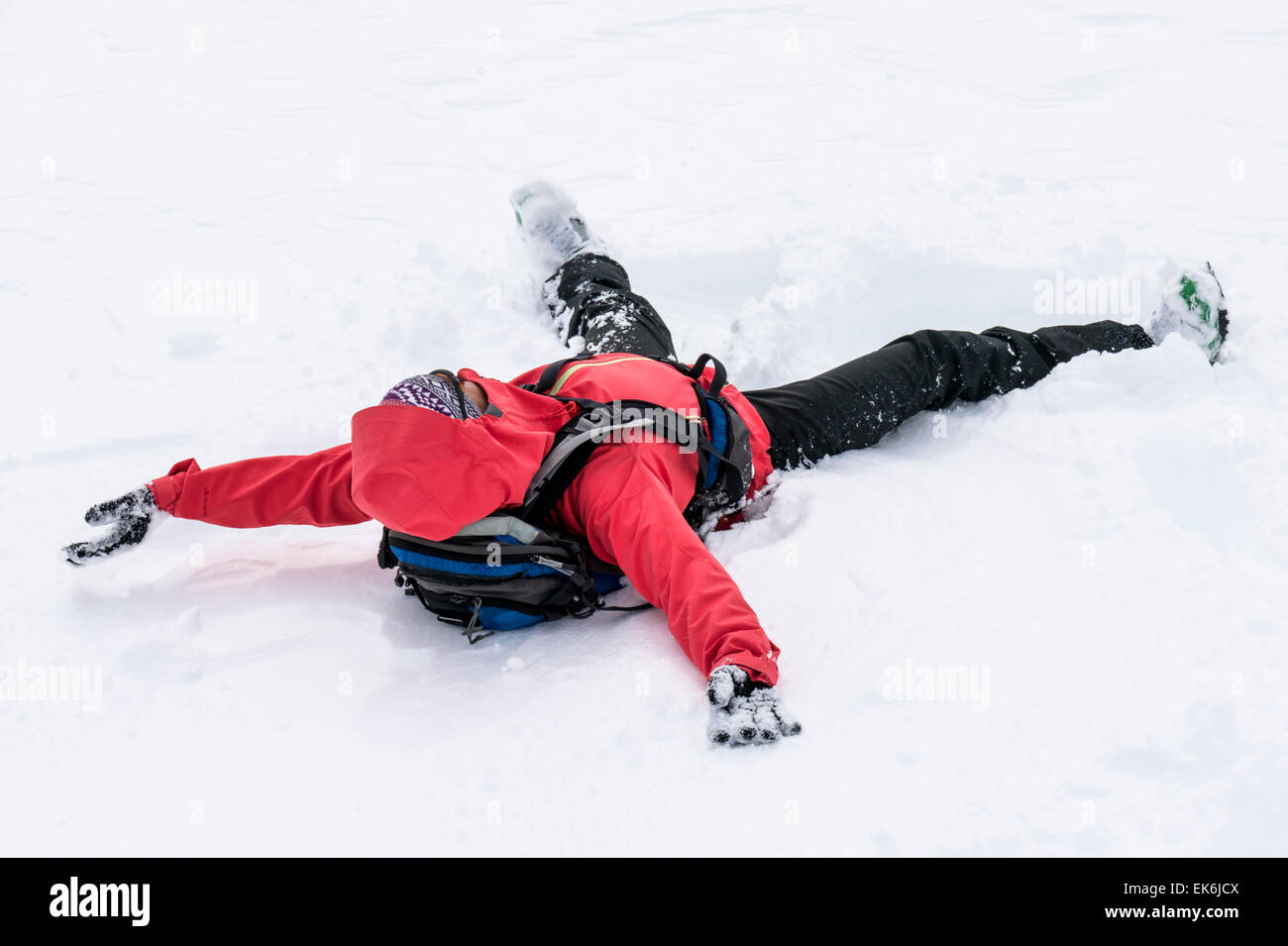 Backcountry skier making a snow angel near the Rifugio Fuciade, Pale di San Martino, Dolomite Mountains, Alps, Italy Stock Photo