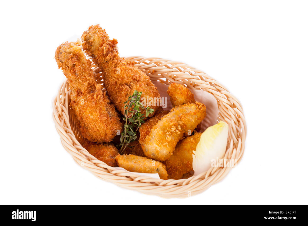 Crisp crunchy golden chicken legs and wings deep fried in bread crumbs and served with a bowl of dip in a wicker basket for a de Stock Photo