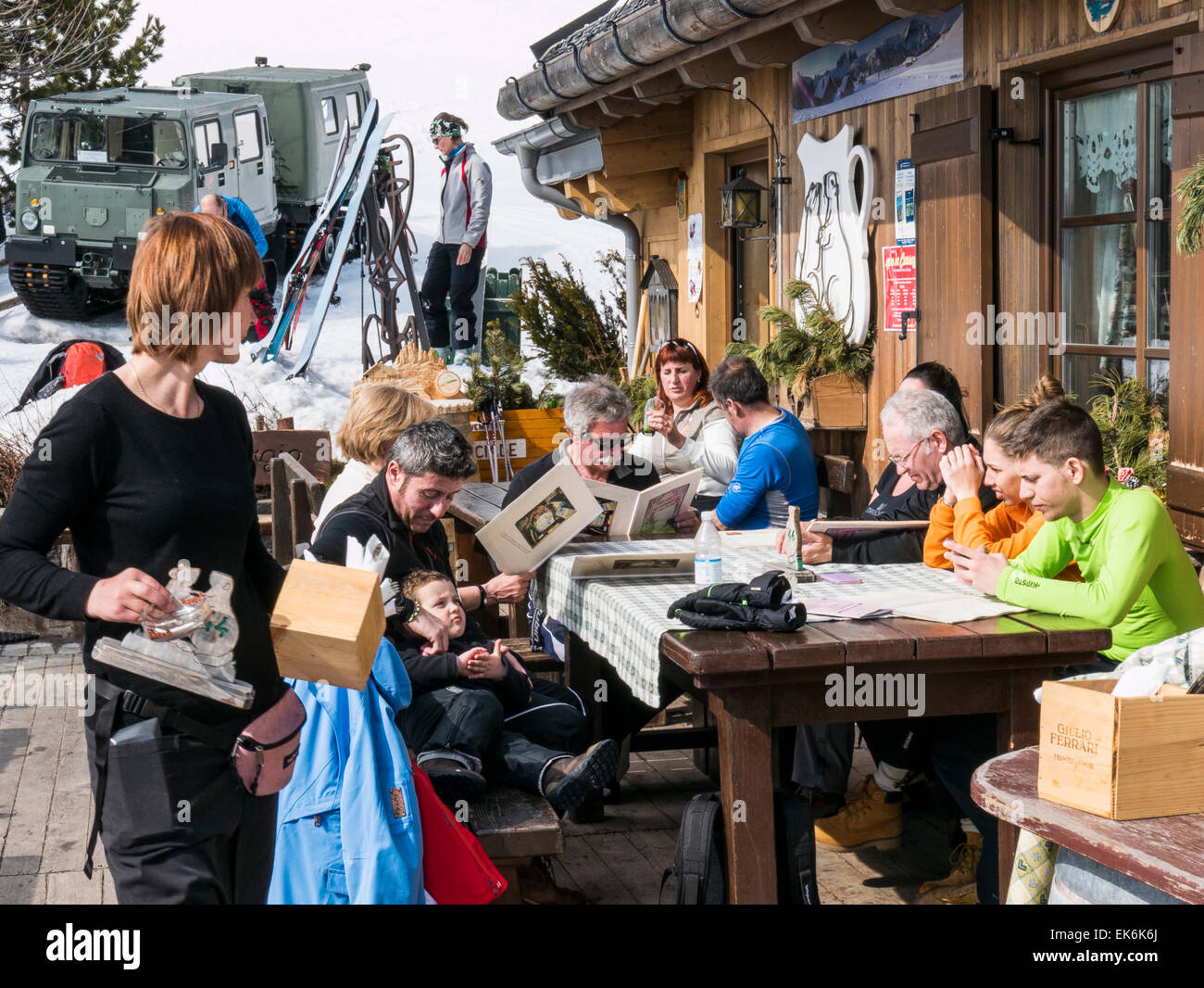 Tourists dining outside on winter day, Rifugio Fuciade, Pale di San Martino, Dolomite Mountains, Alps, Italy Stock Photo