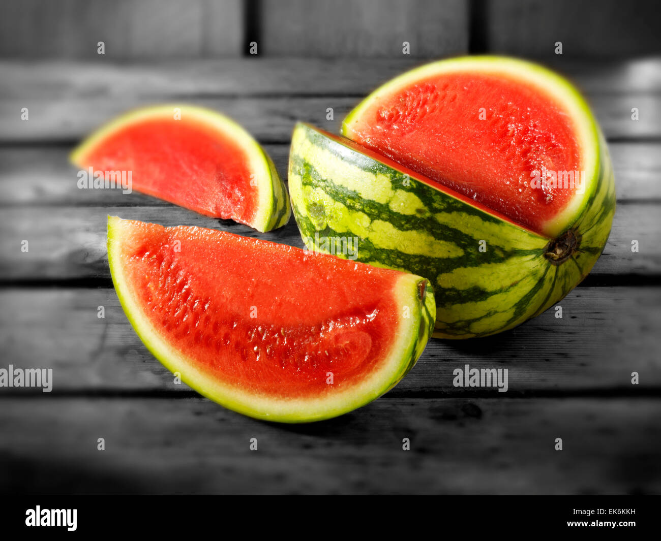 Fresh cut red watermelon, whole and sliced, on a wood background setting Stock Photo