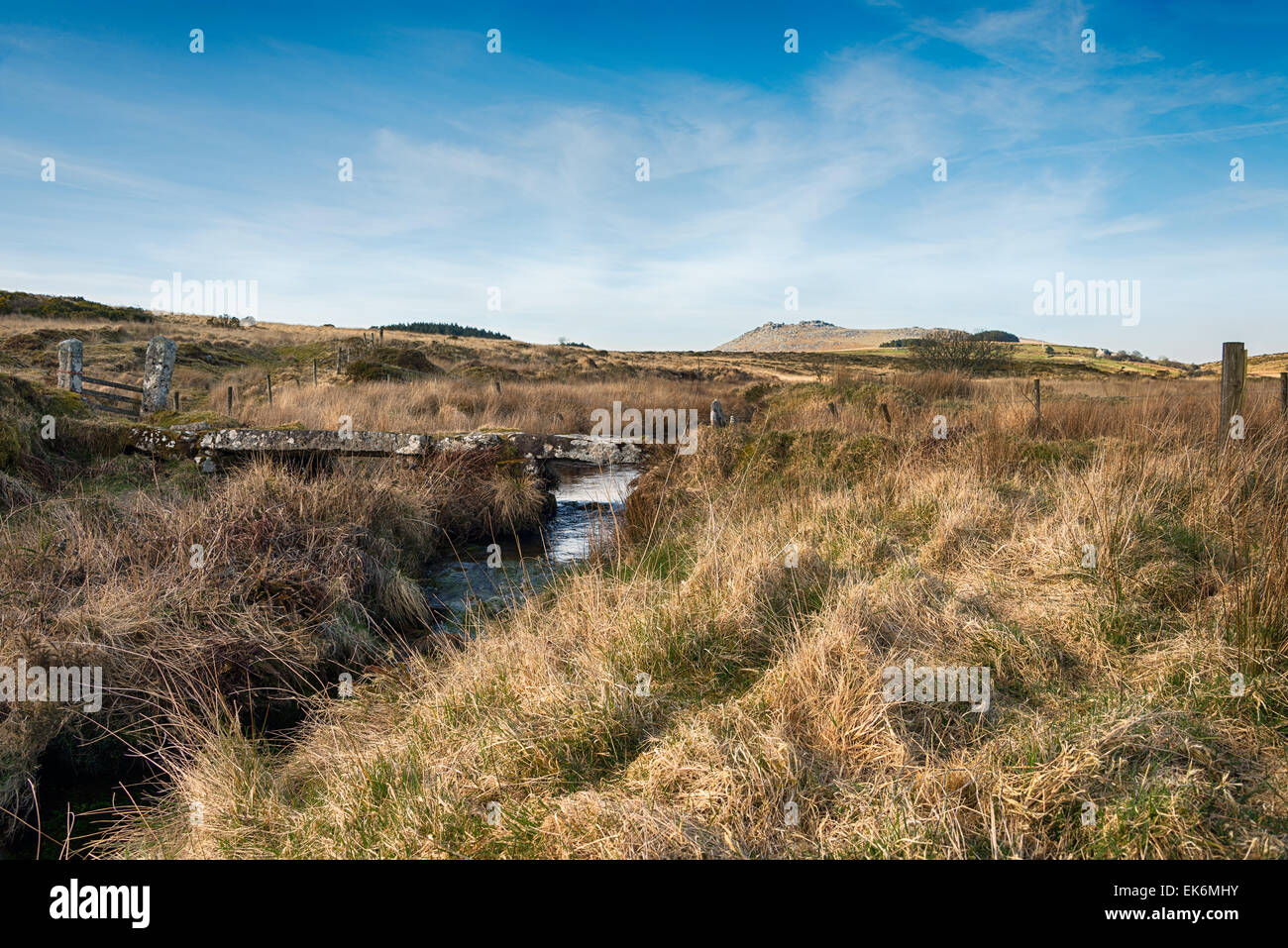 A small stone clapper bridge over De Lank River on Bodmin moor in Cornwall as it winds it's way past Broown Willy with Roughtor Stock Photo