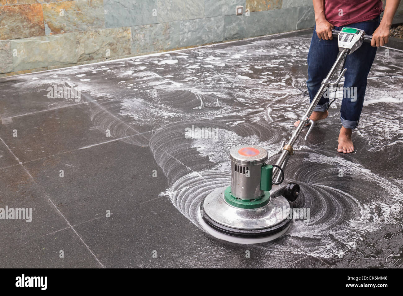 Thai people cleaning black granite floor with machine and chemical
