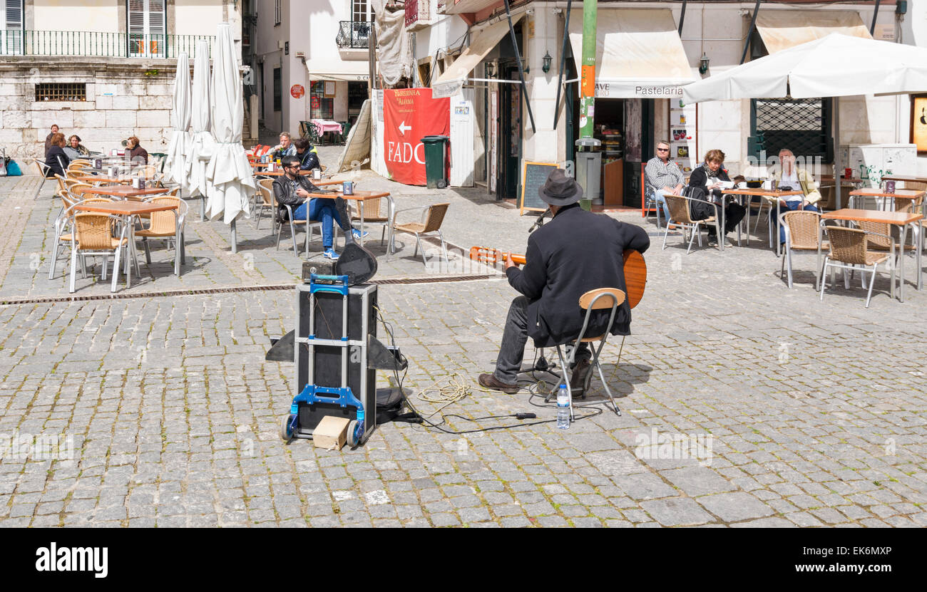 LISBON PORTUGAL MUSICIAN WITH GUITAR PLAYING OUTSIDE A CAFE IN CENTRAL