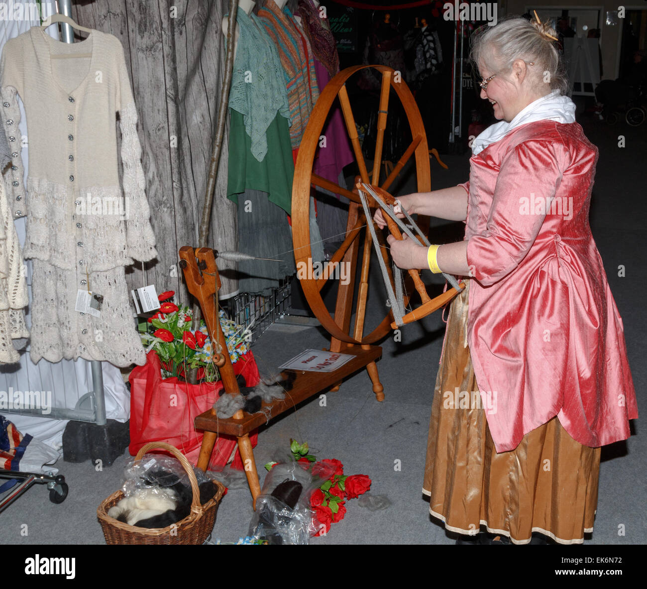 Woman (50-60 years) spinner in traditional costume using a hand driven spinning wheel to spin alpaca yarn Stock Photo