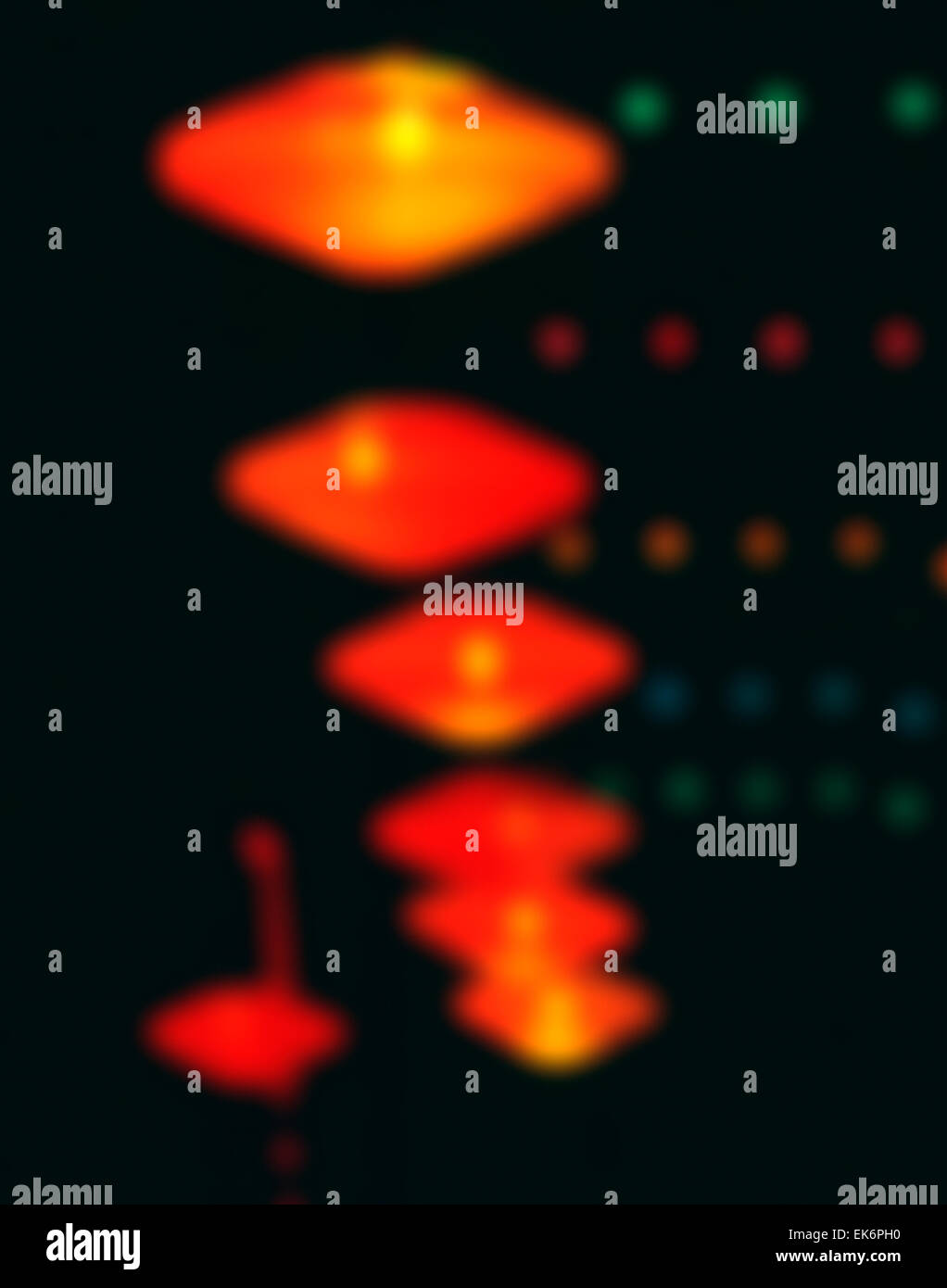 Abstract blurred, out-of-focus view of orange ceiling lights hanging in a hotel lobby. Stock Photo
