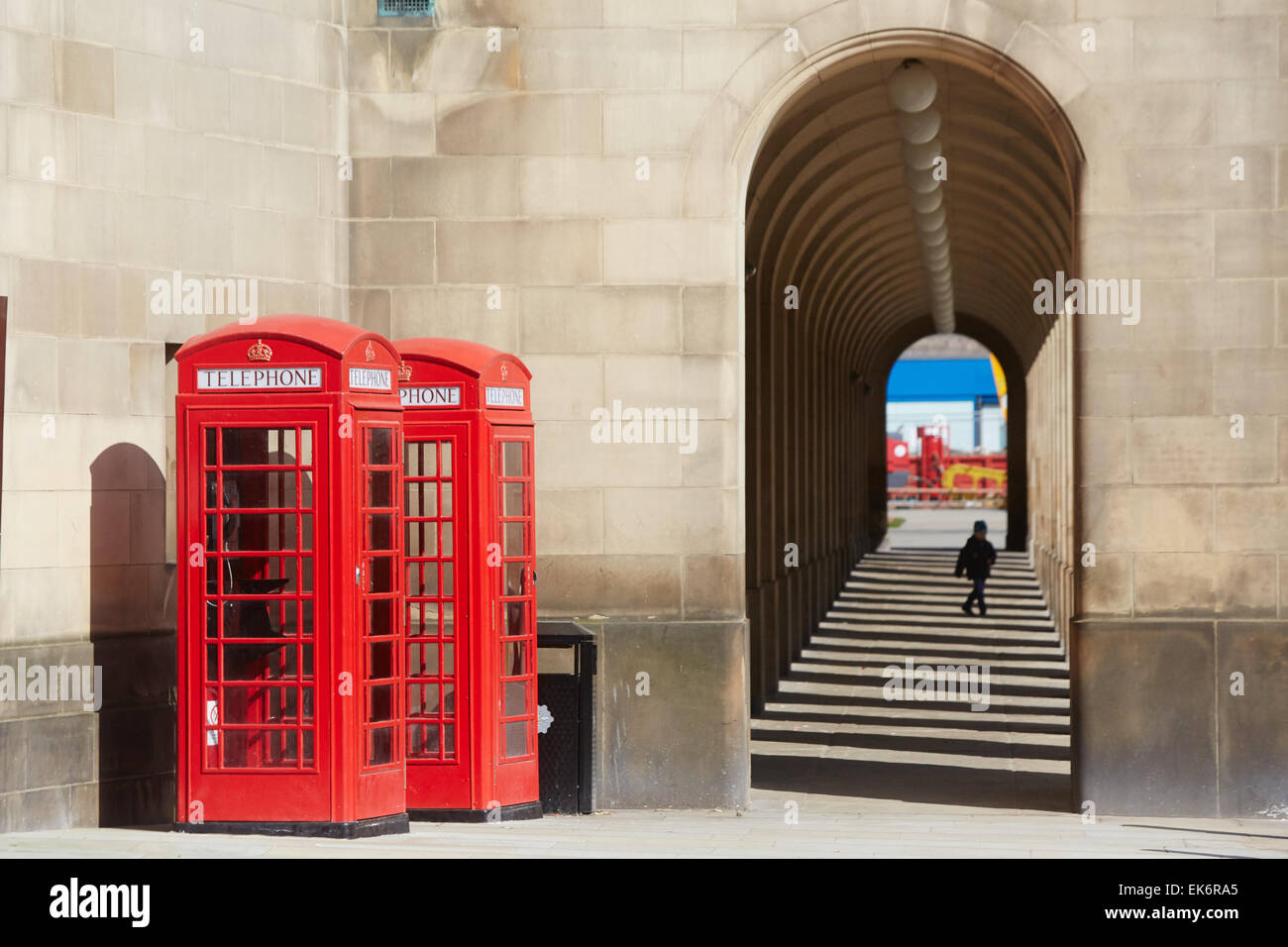 Manchester Town Hall extension arches walkway with red telephone boxes Stock Photo
