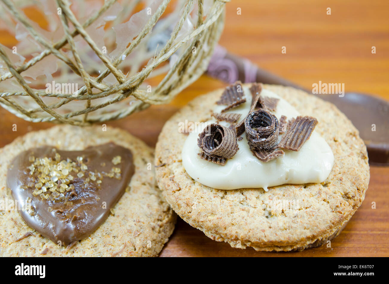 Oatmeal cookies covered  with cream and chocolate on wooden table Stock Photo