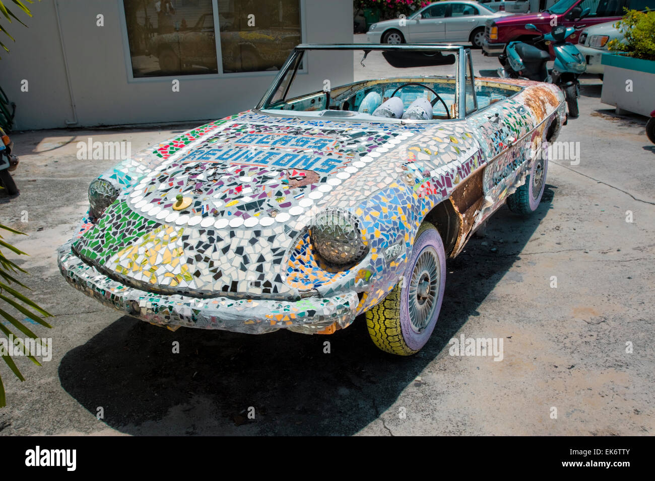 A car decorated with colourful mosaic tiles outside Glass Reunions Art