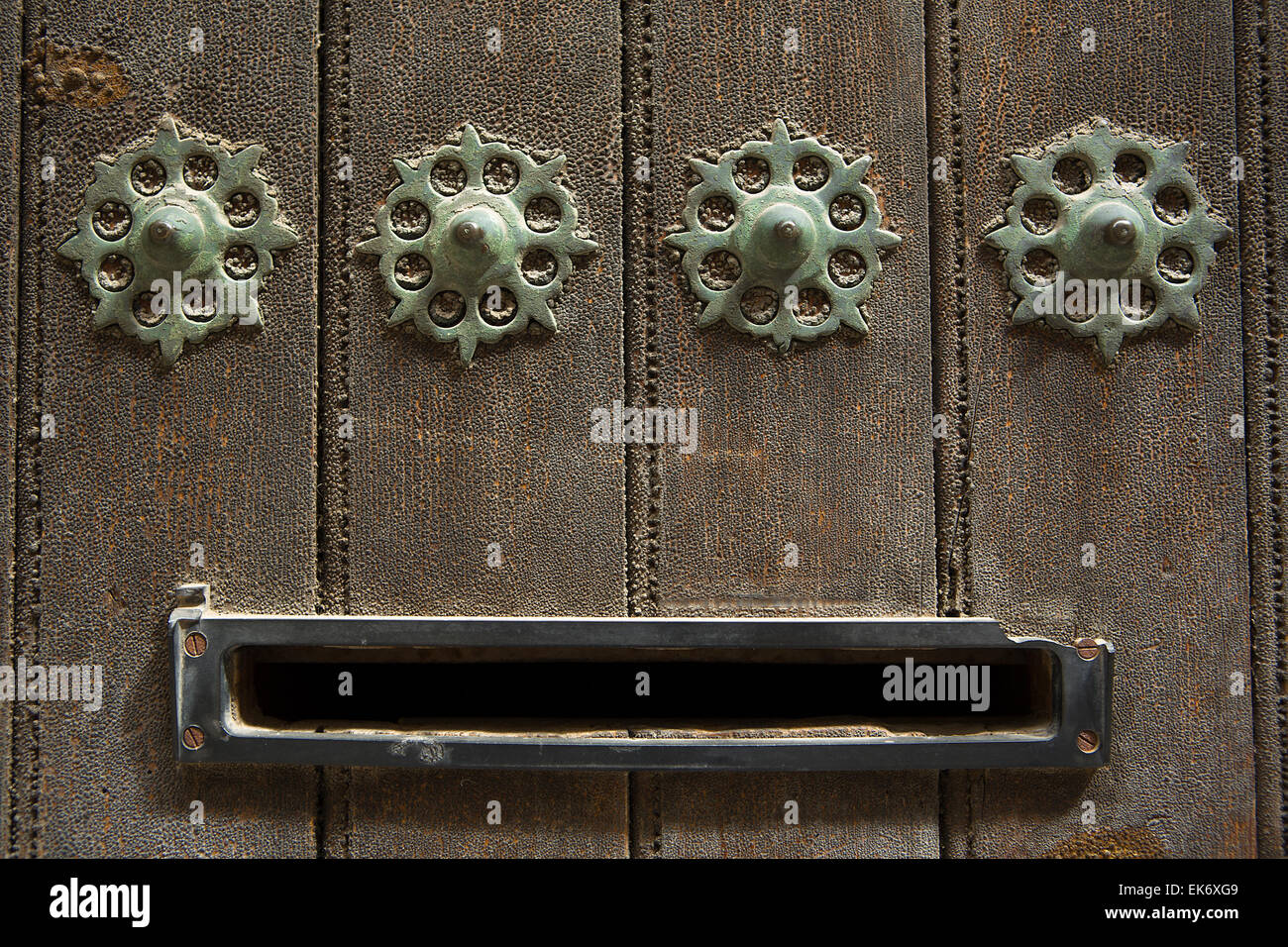 Ancient slot mailbox placed in a wooden door with rivets Stock Photo