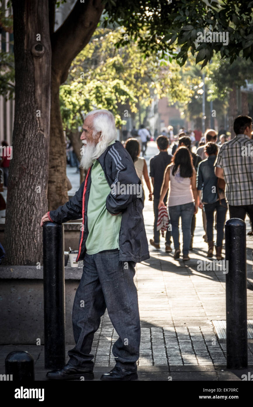 Old homeless man profile in a walking alley Stock Photo