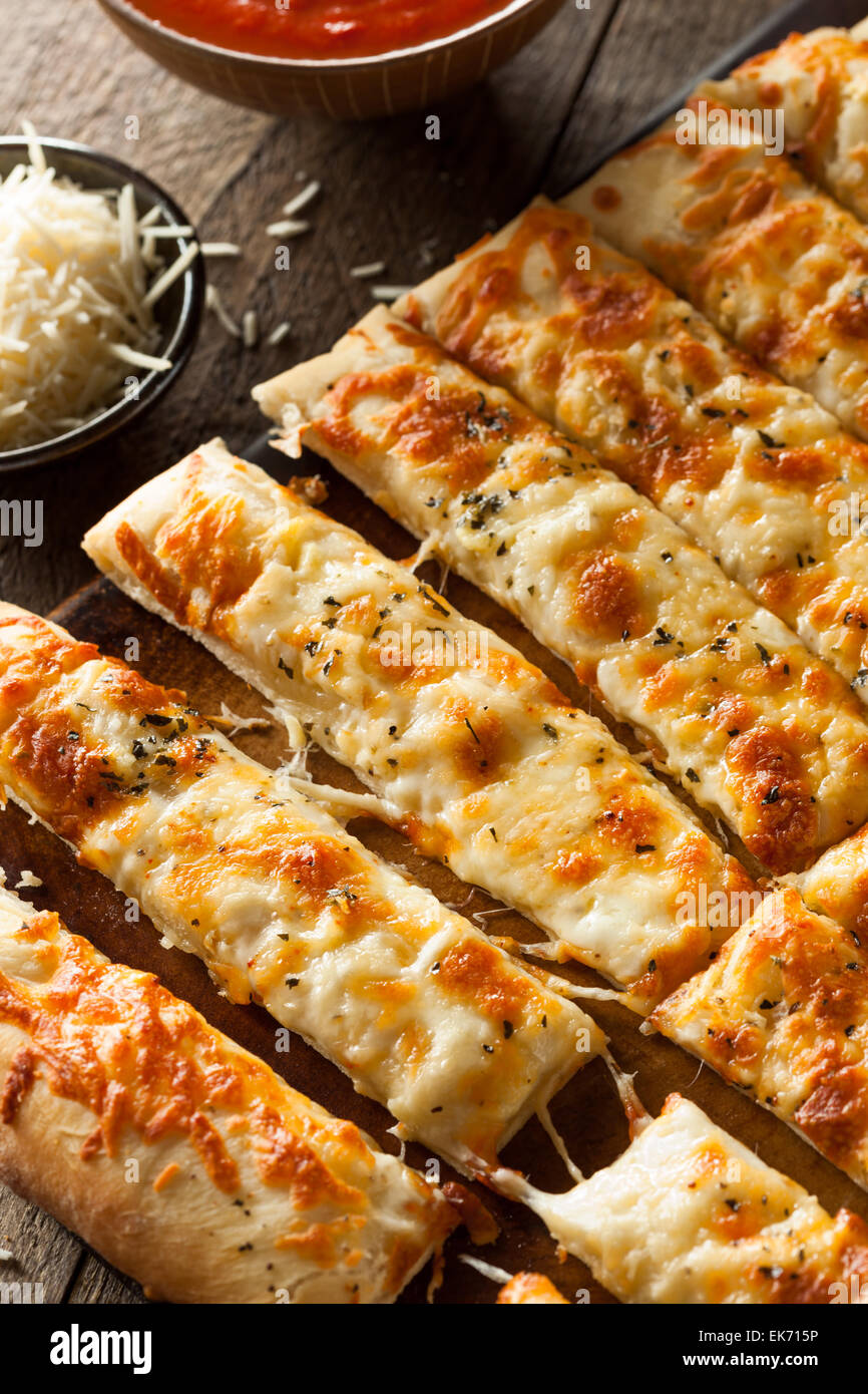 Homemade Cheesy Breadsticks with Marinara Sauce for Dipping Stock Photo